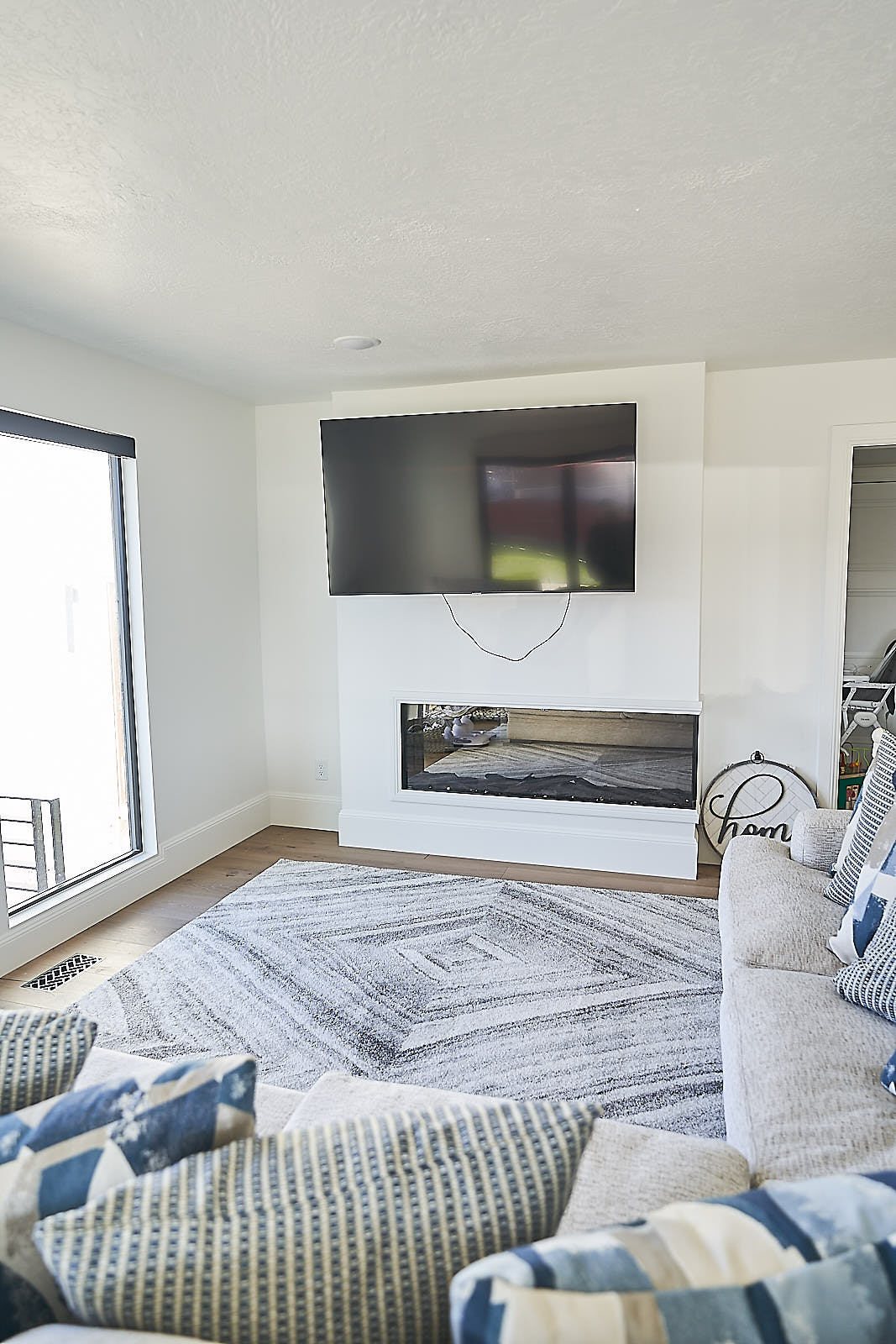 South Jordan project: Modern linear fireplace integrated into a white accent wall with mounted TV (Photo 14/29)