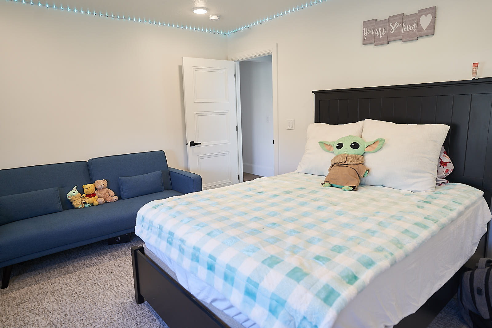South Jordan project: Finished bedroom with a blue sofa, black bed frame, and custom wall decor (Photo 23/29)