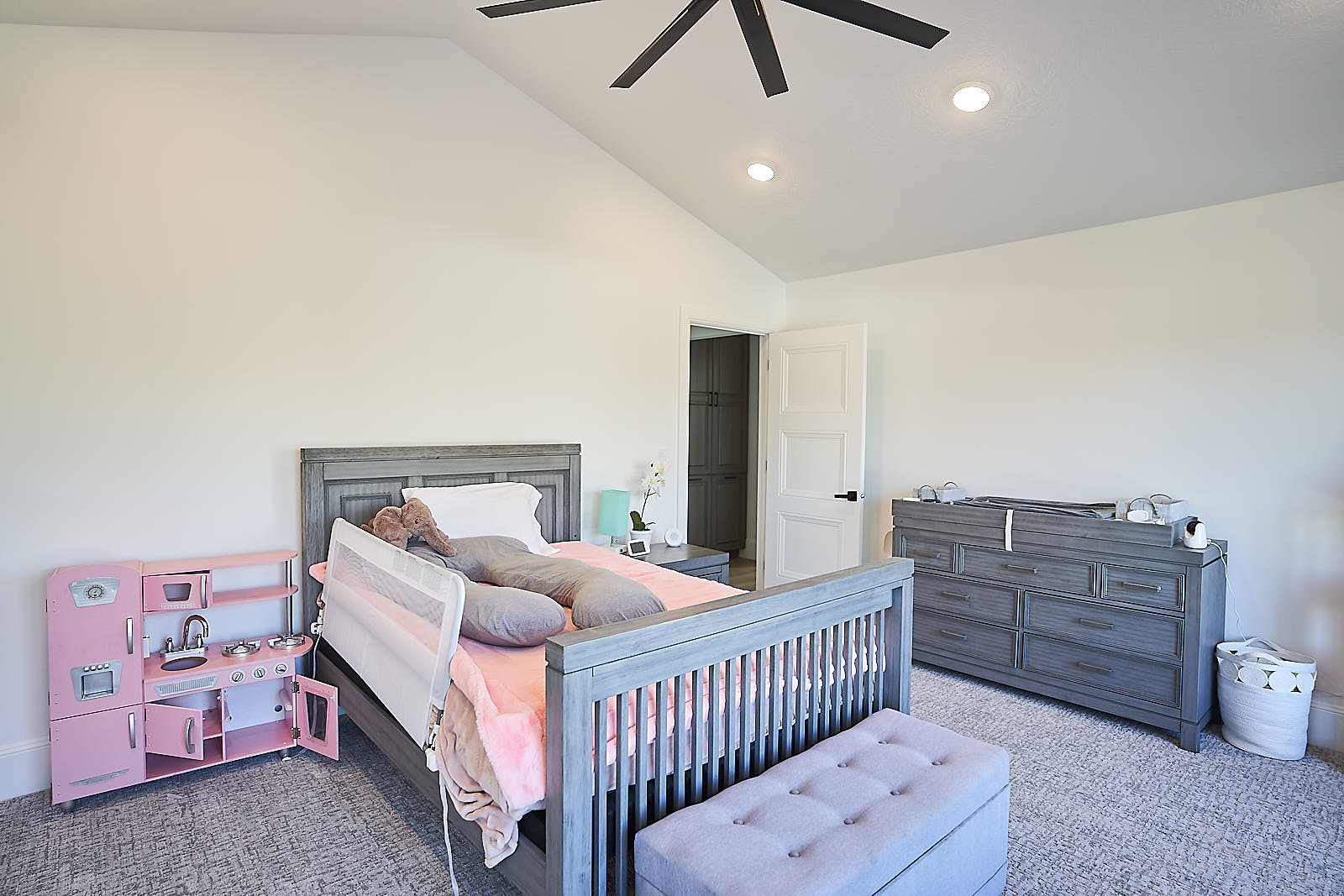 South Jordan project: Child's bedroom with vaulted ceilings, grey furniture, and a pink play kitchen (Photo 24/29)