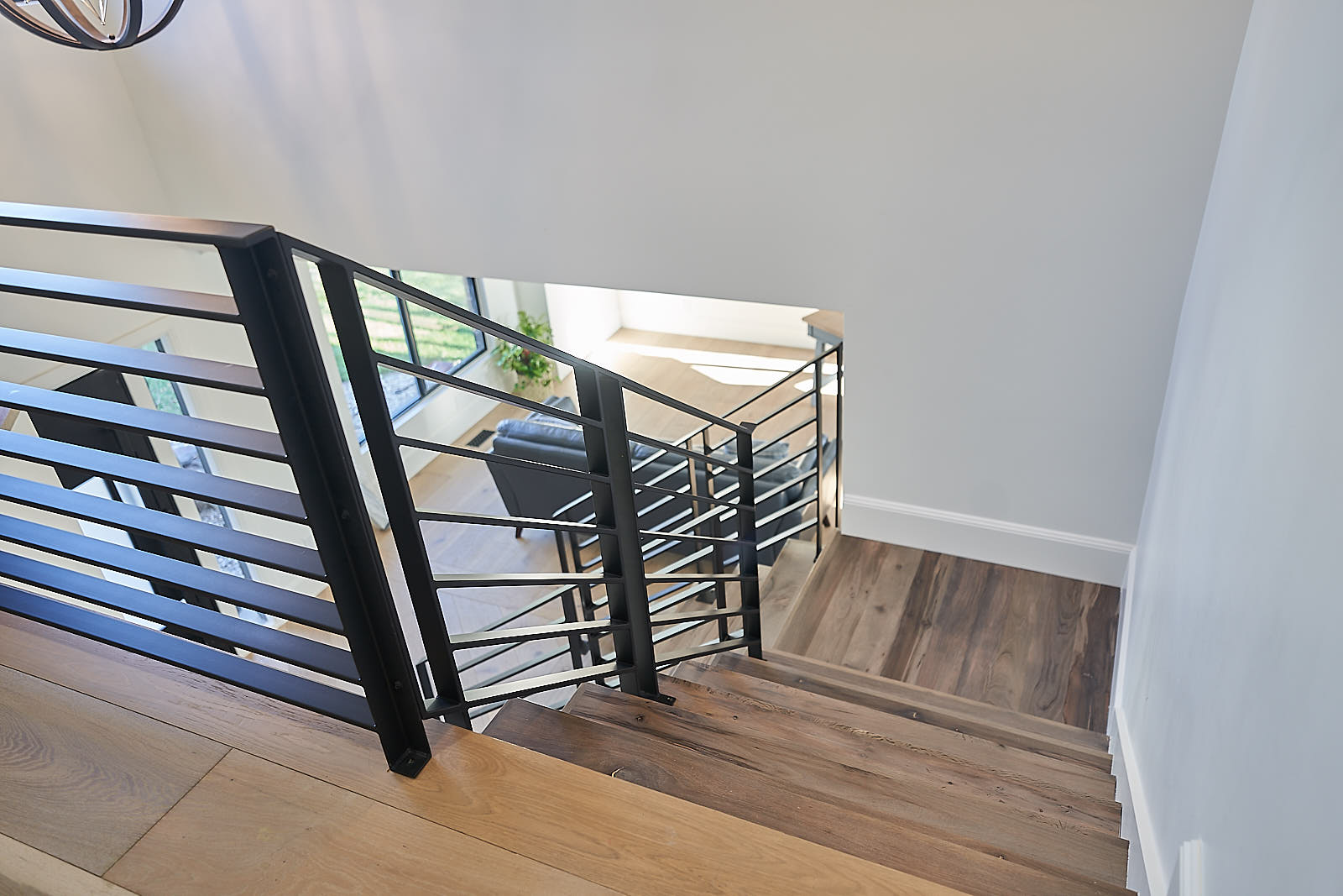 South Jordan project: View from the top of the modern staircase overlooking the open-concept living area (Photo 27/29)