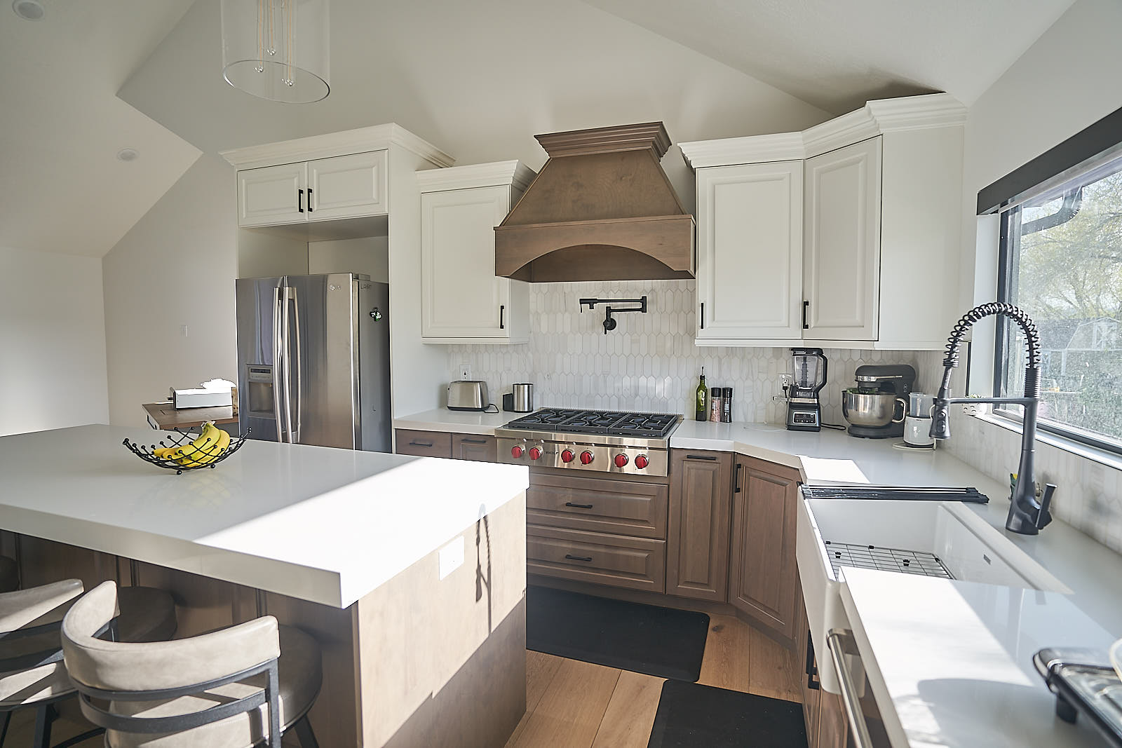 South Jordan project: Spacious kitchen island with white countertop and custom wooden range hood (Photo 4/29)