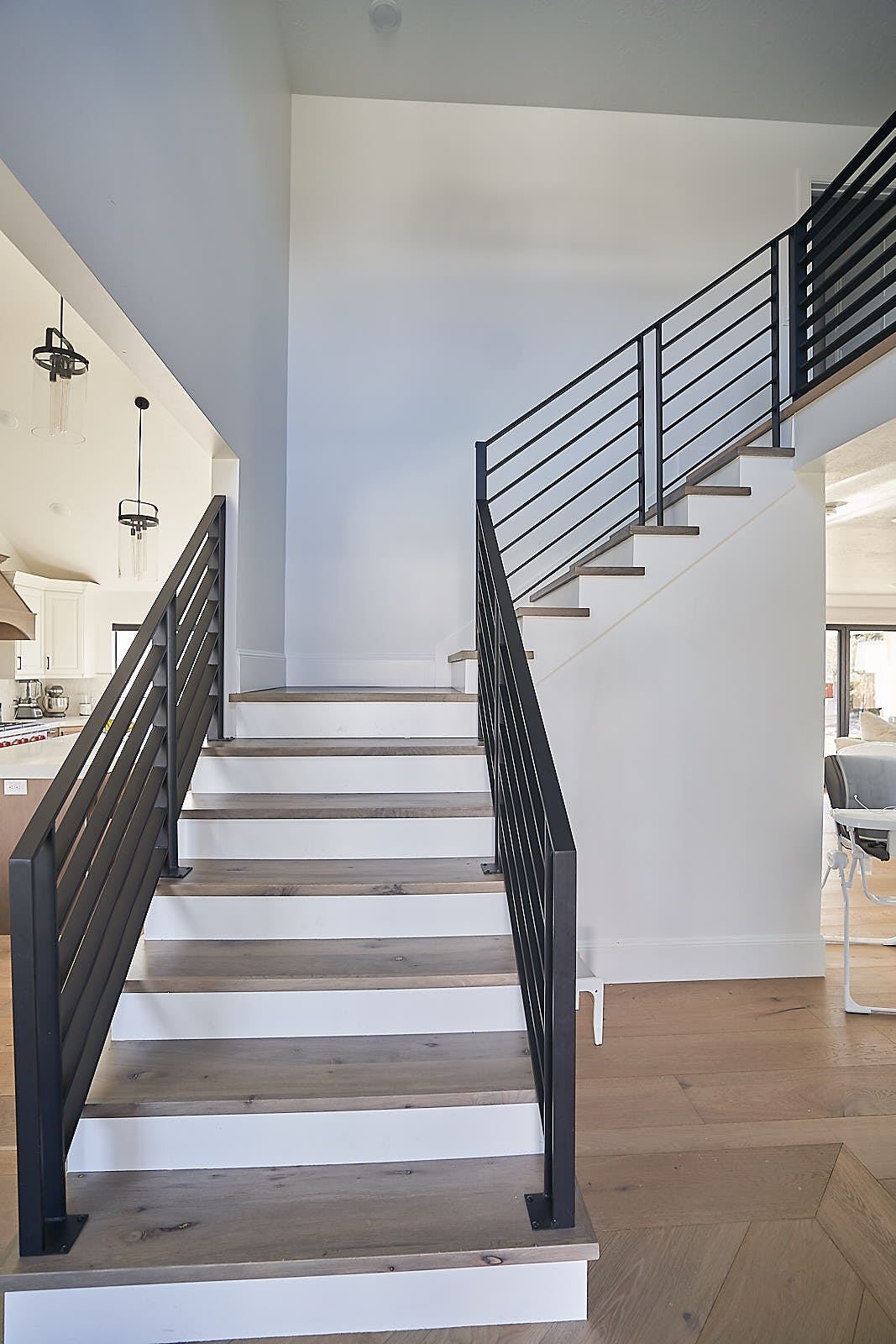 South Jordan project: Modern staircase with dark wood treads and black horizontal metal railing (Photo 6/29)