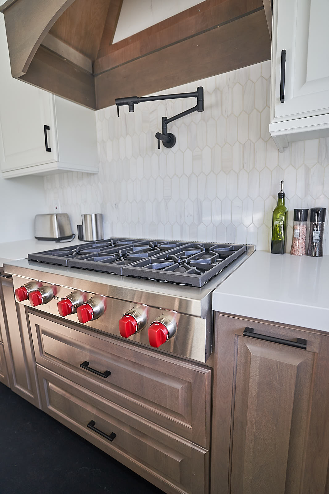 South Jordan project: High-end Wolf range with red knobs and black pot filler against hexagon tile (Photo 8/29)